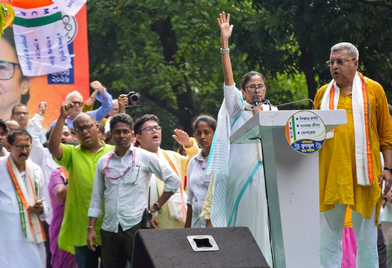 ममता बनर्जी टीएमसीपी स्थापना दिवस के मंच से हाथ उठाकर भीड़ को संबोधित कर रही हैं।